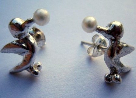 Earrings with silver birds pecking little
                    pearls